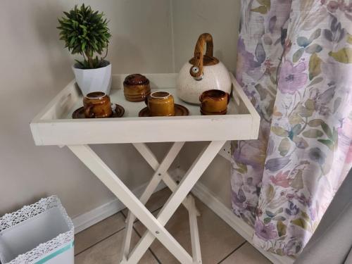 une table blanche avec des bougies dessus à côté d'un lit dans l'établissement La Maison on Vaal Bed and Breakfast, à Denysville