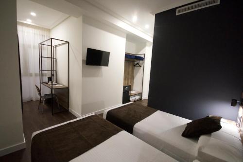 a hotel room with two beds and a tv at Hotel BH San Francisco Alicante in Alicante