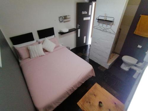 a bedroom with a white bed and a toilet at Exquisite Minimalistic Room in Pietermaritzburg