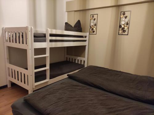 a white bunk bed in a room with a bed at Landperle klein und fein in Altenhof
