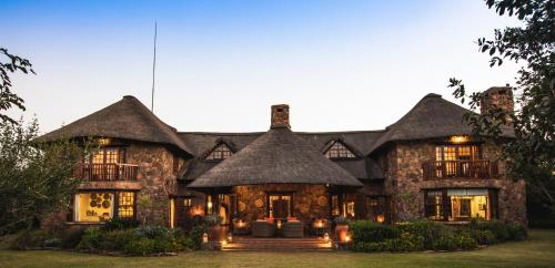 a large stone house with a thatched roof at Jembisa Bush Home in Melk River