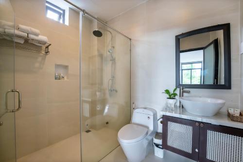 a bathroom with a toilet and a sink and a shower at Hoi An Ivy Hotel in Hoi An