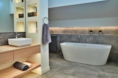 een badkamer met een wit bad en een wastafel bij Pleta de Escaldes 6.1 in Andorra la Vella