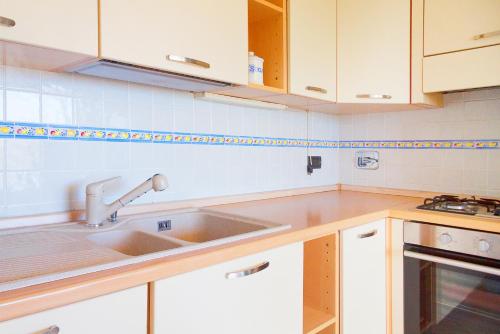 a kitchen with white cabinets and a sink at Giardino La Panoramica in Rio Marina
