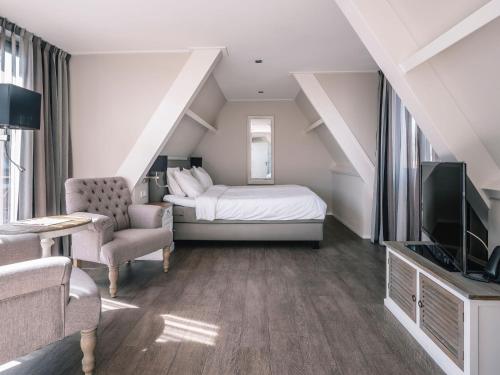 a hotel room with a bed and a tv at Juuls Domburg in Domburg