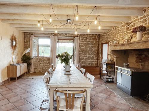 una sala da pranzo con tavolo, sedie e camino di L'ancien Relais de Poste*** a Saint-Dier-dʼAuvergne