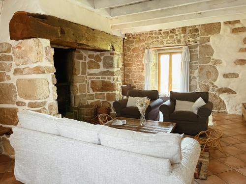 a living room with a couch and a stone fireplace at L'ancien Relais de Poste*** in Saint-Dier-dʼAuvergne