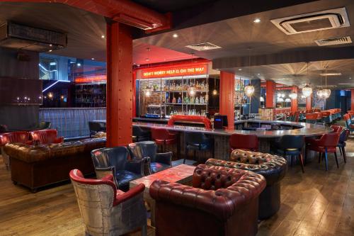 a bar with leather seats and a bar counter at Malmaison Manchester in Manchester