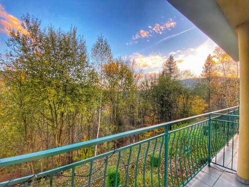 a balcony with a view of the woods at Apartamenty Siódemka Ustroń in Ustroń