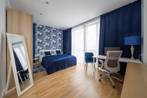 1 dormitorio con cama, escritorio y mesa con sillas en 1-bedroom penthouse with underground parking en Riga
