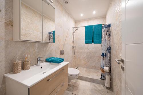 y baño con lavabo, aseo y ducha. en 1-bedroom penthouse with underground parking, en Riga