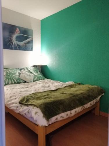 - une chambre dotée d'un lit avec un mur vert dans l'établissement Colorful Appartement near Luz-Saint-Sauveur, à Vizos