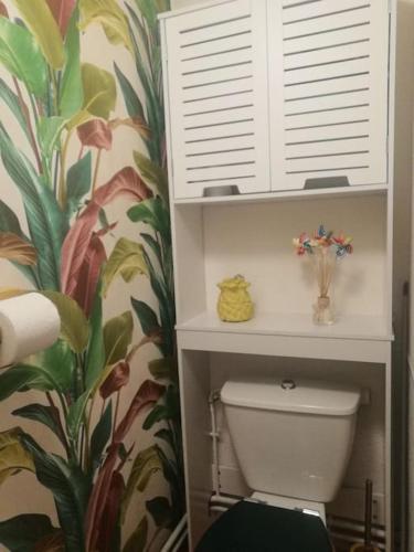 La salle de bains est pourvue de toilettes et de papier peint tropical. dans l'établissement Colorful Appartement near Luz-Saint-Sauveur, à Vizos