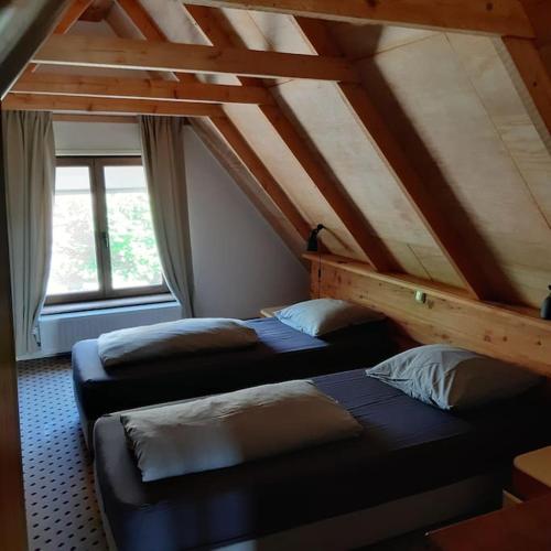 a attic room with two beds and a window at Country cottage Anna Paulowna, self checkin in Anna Paulowna
