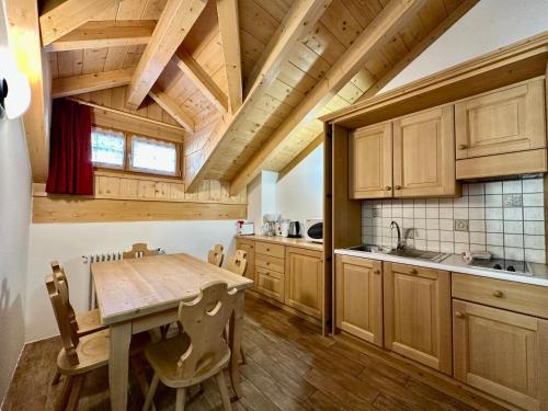 a kitchen with wooden cabinets and a wooden table at Cesa Planber Apartments Mountain View BIKE FRIENDLY in Canazei
