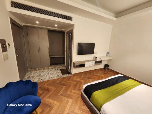 1 dormitorio con 1 cama, TV y sofá en Square9 - A Boutique Hotel, en Gurgaon