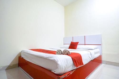 um quarto com uma cama grande com duas toalhas em RedDoorz at Buah Batu 5 em Bandung