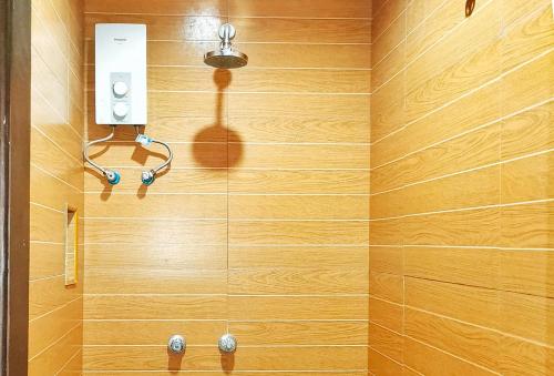 uma casa de banho com uma parede de madeira e um chuveiro em RedDoorz @ Jackie’s Hotel & Restaurant em Ipil
