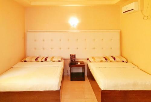 Duas camas individuais num quarto com uma mesa em RedDoorz @ Jackie’s Hotel & Restaurant em Ipil