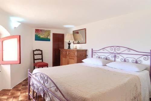 1 dormitorio con 1 cama grande y 1 silla en Dimora degli Artisti - Ciolo private sea access, en Gagliano del Capo