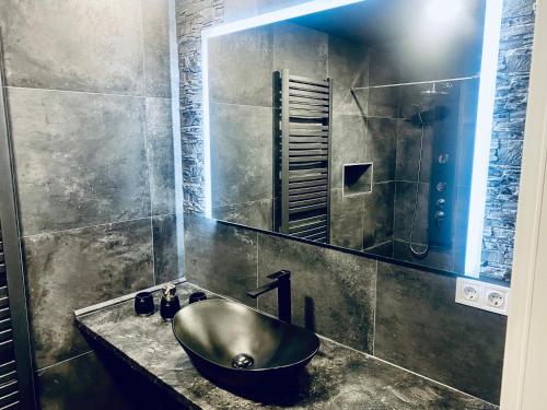 a bathroom with a sink and a mirror at Trendy House 158 in Mátranovák