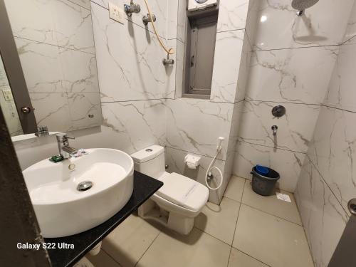 a white bathroom with a sink and a toilet at Square9 - A Boutique Hotel in Gurgaon