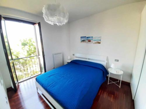 um quarto com uma cama azul e uma grande janela em R18 Residence Adamo e Eva nuovo bilocale em Marcelli