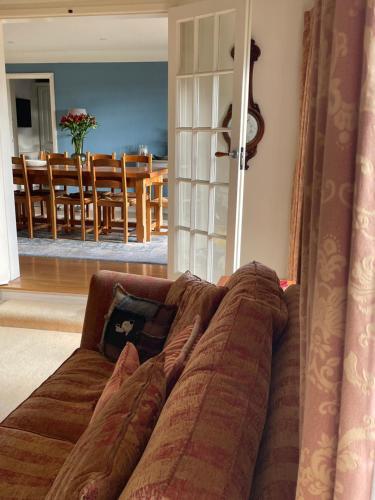 a couch in a living room with a dining room at Appletree Cottage in Heswall