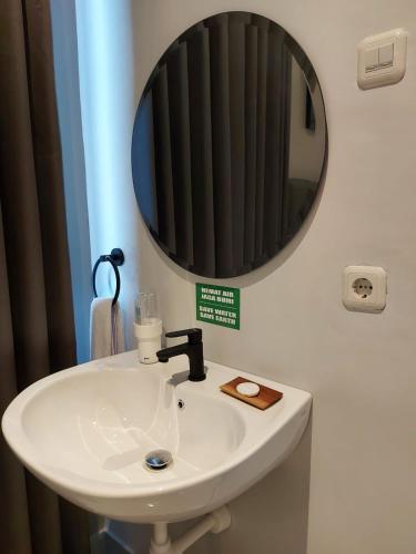 a bathroom with a sink and a mirror at Atap Biru Residence in Semarang