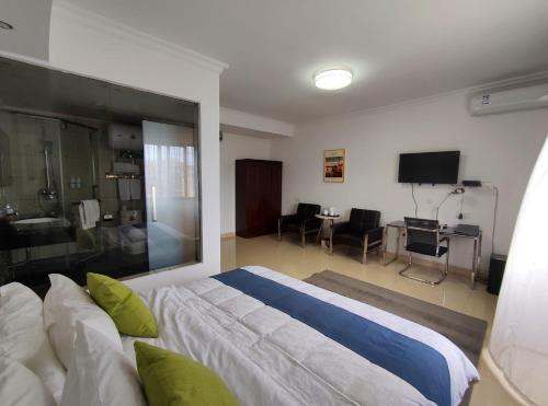 a bedroom with a large bed and a living room at Feima Hotel in Antananarivo