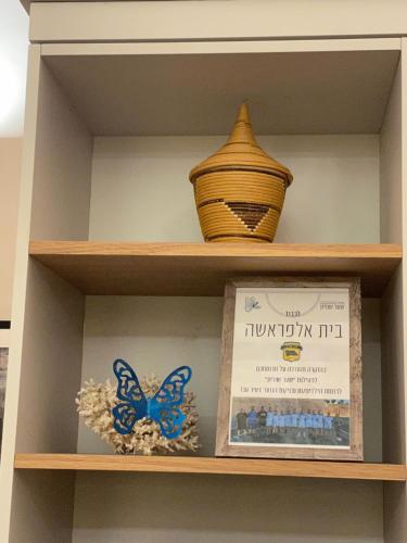półka z dwoma wazami i pudełkiem. w obiekcie Beit Elfarasha w mieście Akka