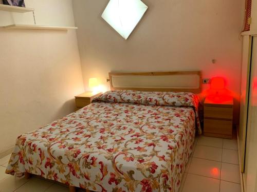 a bedroom with a bed and a red object on a table at Rio Piccolo Apartment in Principina a Mare