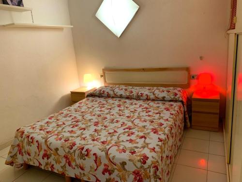1 dormitorio con 1 cama y un objeto rojo sobre una mesa en Rio Piccolo Apartment, en Principina a Mare