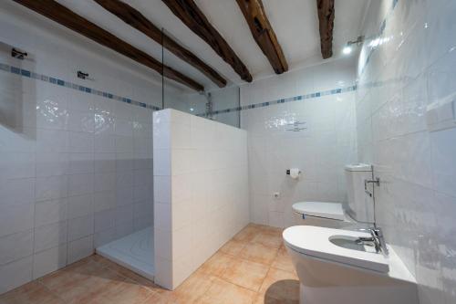 a white bathroom with a toilet and a shower at VILLA ES CUBELLS COUNTRY & SEA in Es Cubells