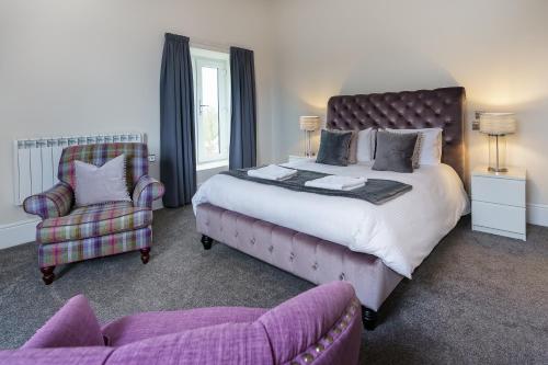 a bedroom with a large bed and a chair at Woodlands Hall Hotel in Ederyn