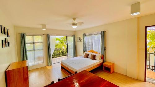 1 dormitorio con 1 cama y 2 ventanas en La Concepcion Cove Garden Resort, en Moalboal