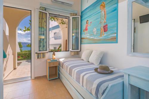 a bedroom with a bed and a view of the ocean at Haraki Mare Studios beach front in Haraki