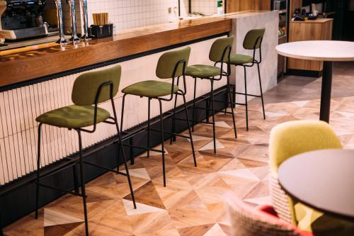 a row of chairs lined up against a bar at ibis Belfast City Centre in Belfast
