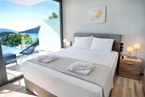 a bedroom with a bed with two towels on it at Diamond Blue Villas Lefkada in Nydri