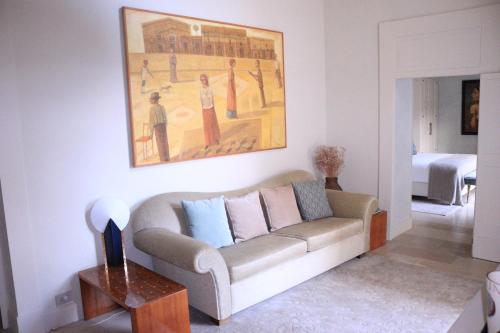 a living room with a couch and a painting on the wall at Palazzo Maresgallo Suites & SPA in Lecce