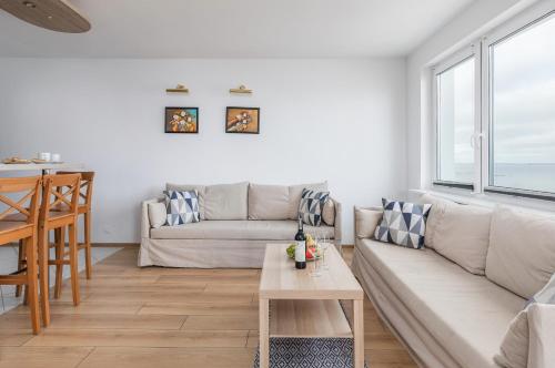 salon z kanapą i stołem w obiekcie Apartament przy Plaży - Campingowa - Widok na Morze by Noclegi Renters w mieście Międzyzdroje