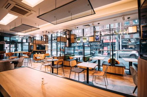 a restaurant with tables and chairs and windows at ibis Belfast City Centre in Belfast