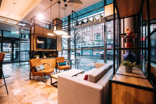 a lobby with a couch and chairs in a building at ibis Belfast City Centre in Belfast