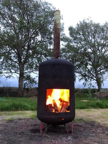 a black stove with a fire inside of it at Farm apartment, self checkin in Anna Paulowna
