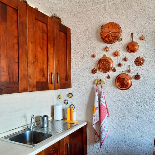 a kitchen with a sink and some plates on the wall at Appartamento Monte Muggio - Your Mountain Holiday in Casargo