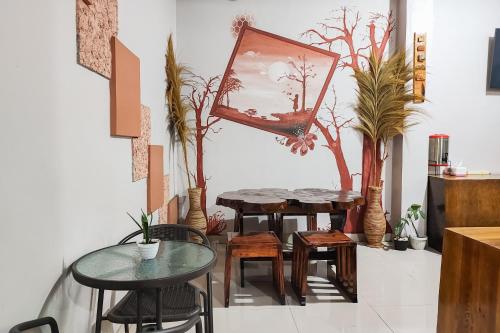 una stanza con due tavoli, sedie e uno specchio di RedDoorz Syariah Near Tugu Macan Kayu Aro a Kayu Aro