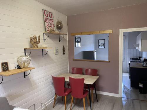 ein Esszimmer mit einem Tisch und roten Stühlen in der Unterkunft Appartement au centre de Dinard in Dinard