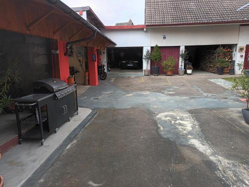 - un barbecue à l'extérieur d'un bâtiment avec garage dans l'établissement Feriendomizil Burgert EG Nähe Europapark, à Kippenheim