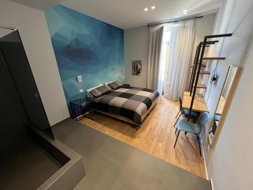 Un dormitorio con una cama y una pared azul. en Terrazza Sangiuliano, en Catania