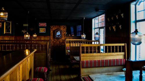 un restaurante con bancos, mesas y ventanas en Signinn en Varde
